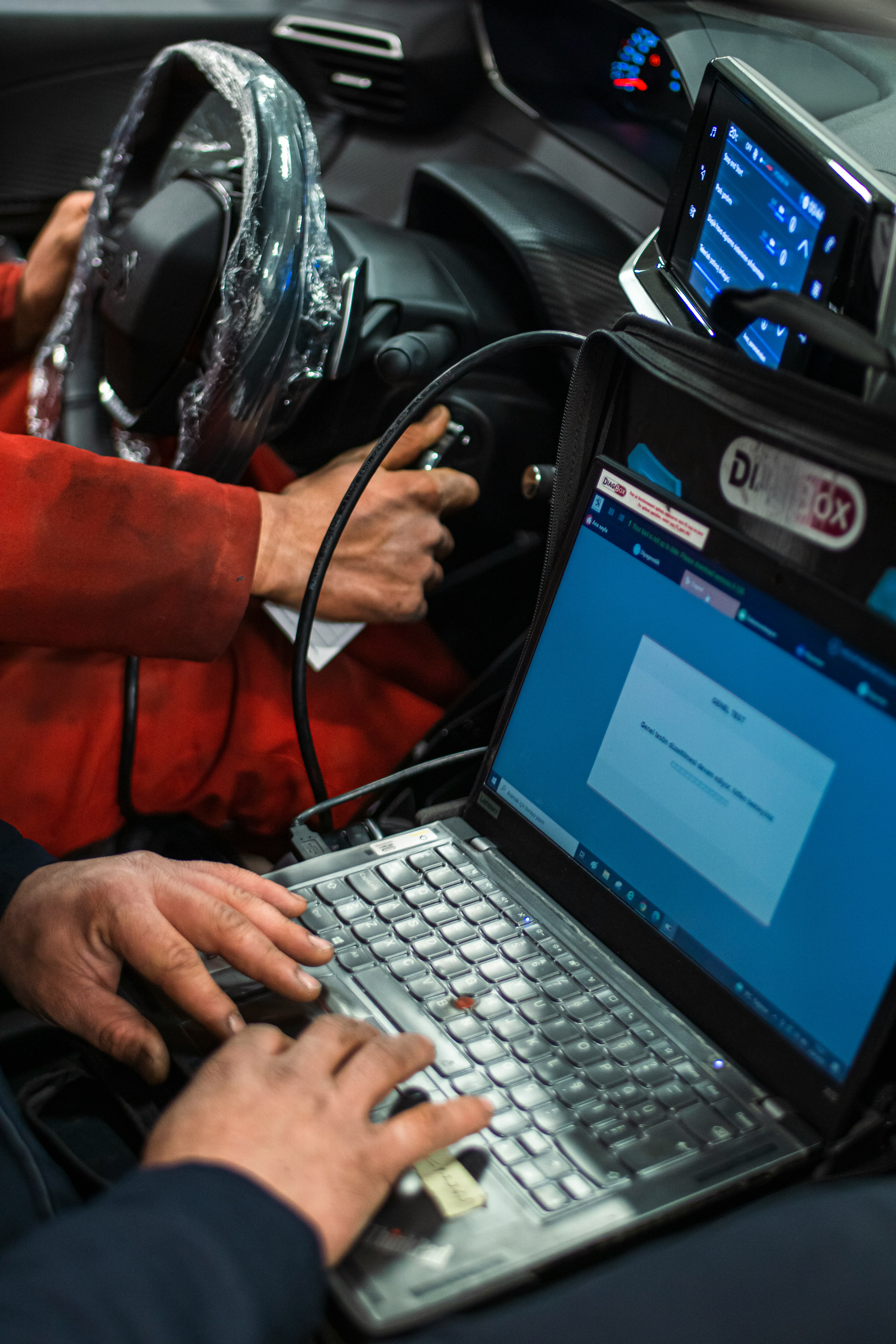 Diagnosticare auto realizată cu tester electronic în interiorul automobilului