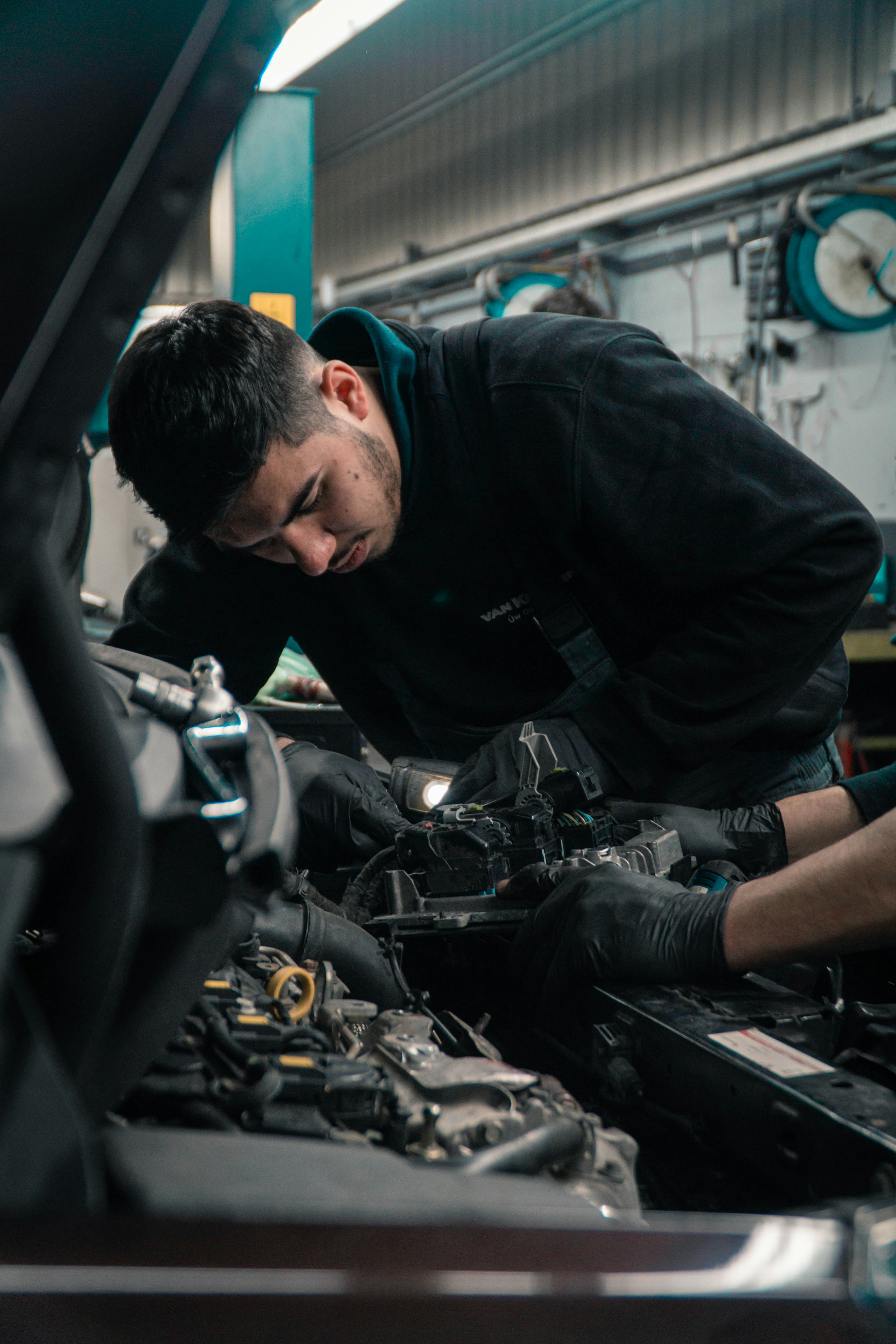 Tehnician lucrând la sistemele electrice și electronice din compartimentul motor